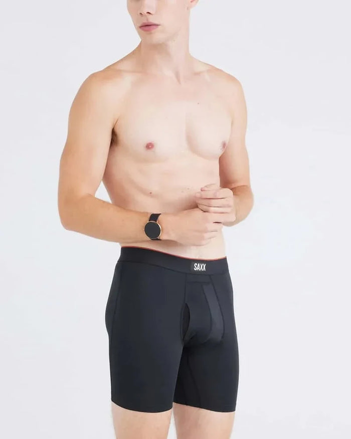 Side view of a model wearing black SAXX Multi-Sport Mesh boxer briefs.