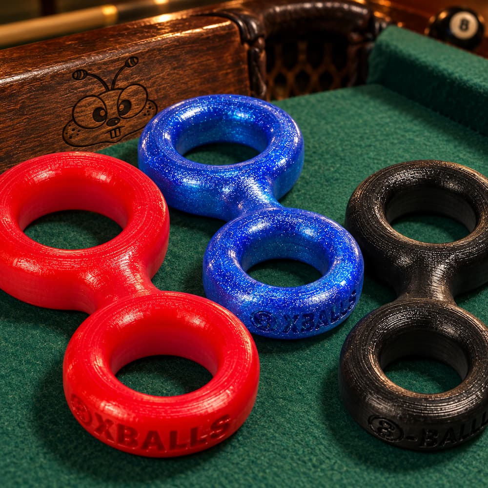 Oxballs 8-Ball silicone cockrings in blue, red and black on green pool-table felt