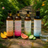 Four Sliquid Splash wash bottles displayed with fruit on a garden path