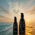 Two Wicked Hybrid pump bottles against a sunset ocean backdrop