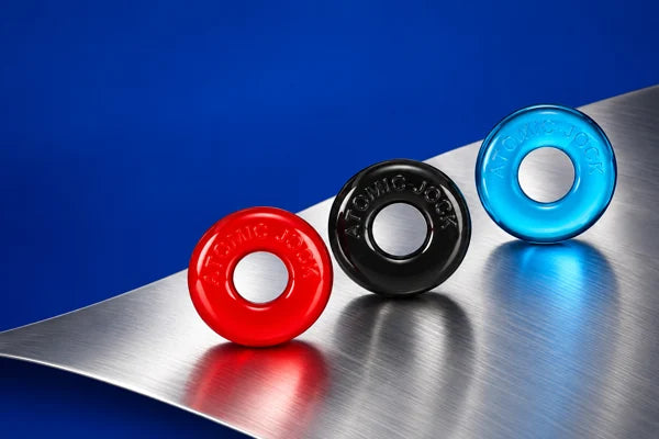 Red, black and cyan RINGER rings on brushed metal against cobalt blue.